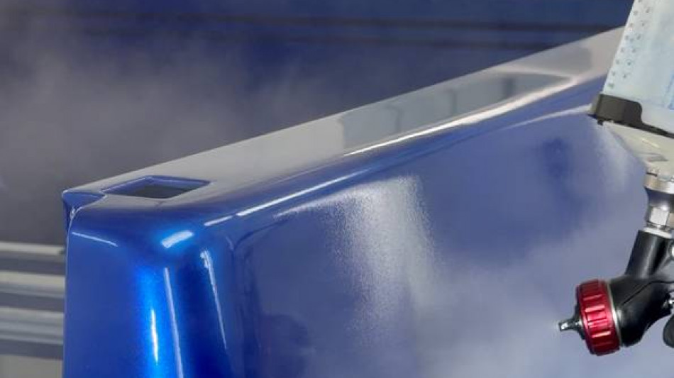 Close-up of blue paint being sprayed onto a Project REBORN-001 body panel